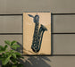 a saxophone on a wall, with a plant to the left of the saxophone.