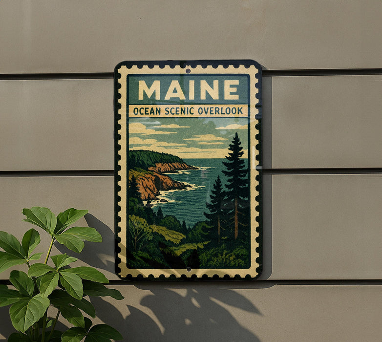 A framed vintage-style sign depicting a scenic coastal landscape with mountains, trees, and the ocean, mounted on a wall.