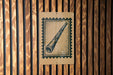 A wooden wall with a rectangular sign featuring an illustration of a telescope or binoculars.
