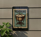 A metal sign with a drum design and the word "TIMPANI" on it, mounted on a wall.