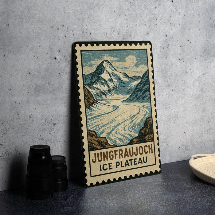 A framed illustration of a mountain landscape with a river, depicting the Jungfraujoch Ice Plateau, is displayed on a table.