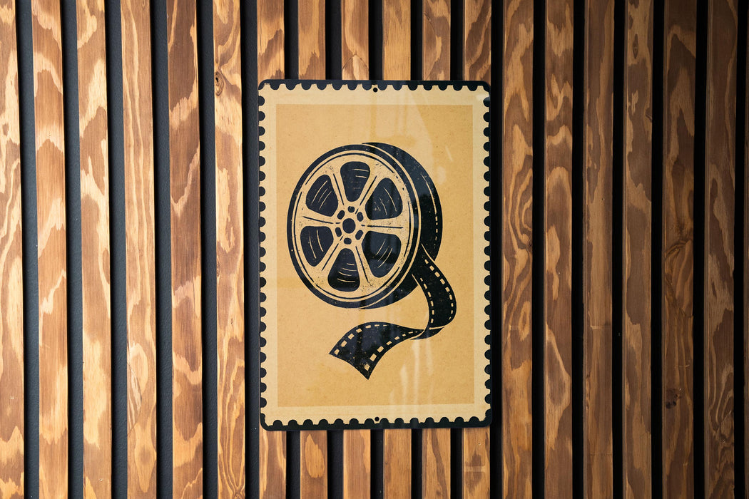 A poster with a film reel on it is displayed on a wooden wall.