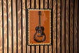a guitar poster displayed on a wooden wall.