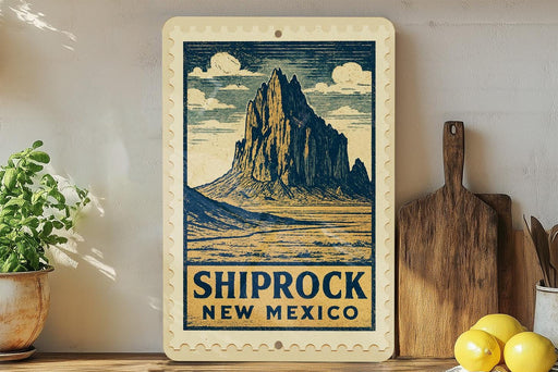 A framed illustration of a mountain landscape with the text "SHIPROCK NEW MEXICO" is displayed on a shelf, accompanied by a wooden cutting board and a potted plant.
