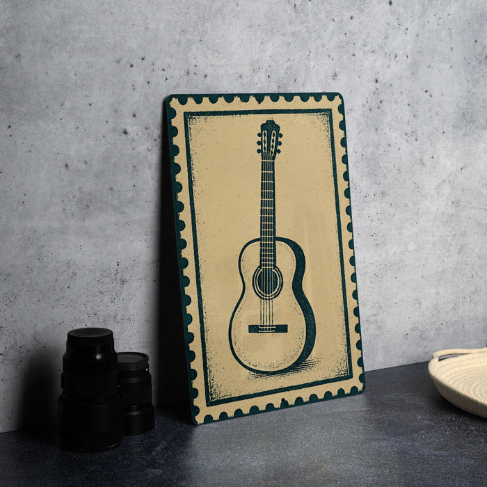 a framed picture of a guitar on a wall, with a stack of black camera lenses and a woven basket placed next to it.