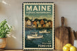 A vintage Maine postage stamp featuring a harbor scene with boats, displayed on a shelf next to a wooden cutting board and some lemons.