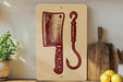 a wooden cutting board with a knife and a hook, along with some lemons and a potted plant, all placed on a shelf.