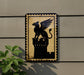 a sign with a black silhouette of a winged lion or mythical creature, mounted on a wall.
