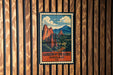 A vintage-style poster of a mountainous landscape with the text "GARDEN OF THE GODS OVERLOOK CO" displayed on a wooden wall.