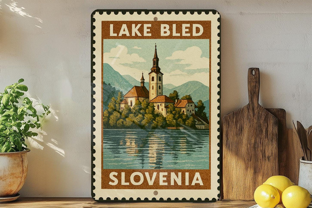 A framed vintage-style poster of Lake Bled, Slovenia, featuring a church and a lake surrounded by mountains.