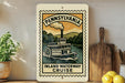 A framed poster of a steamboat on the Inland Waterway Cruise, with the text "Pennsylvania" and "Inland Waterway Cruise" printed on it, is displayed on a shelf next to a wooden cutting board and some lemons.