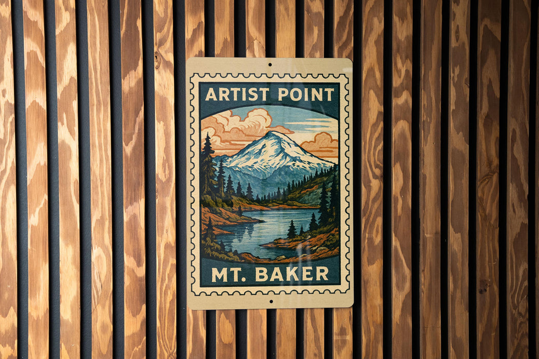 A vintage-style metal sign with a mountain landscape and a river, mounted on a wooden wall.