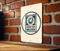 a sign with the text "COIN-OP WASHER" on it, mounted on a brick wall.