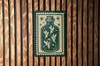 A green and white sign with a fairy illustration is displayed on a wooden wall.