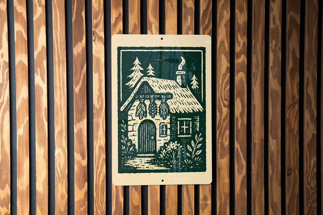 A wooden wall with a sign featuring a black and white illustration of a cabin with a chimney, surrounded by trees and bushes.