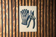 A sign with a pair of gardening gloves and pruning shears is displayed on a wooden wall.
