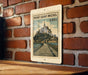 A vintage-style metal sign depicting the Mont Saint-Michel, a famous landmark in France, mounted on a brick wall.