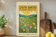A framed poster of a field of wildflowers, with the text "SOUTH DAKOTA WILDFLOWER MEadows Trail" displayed prominently.