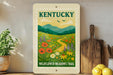 A framed poster of Kentucky's Wildflower Meadows Trail, featuring a vibrant illustration of a meadow filled with colorful wildflowers and a winding path leading through the landscape.