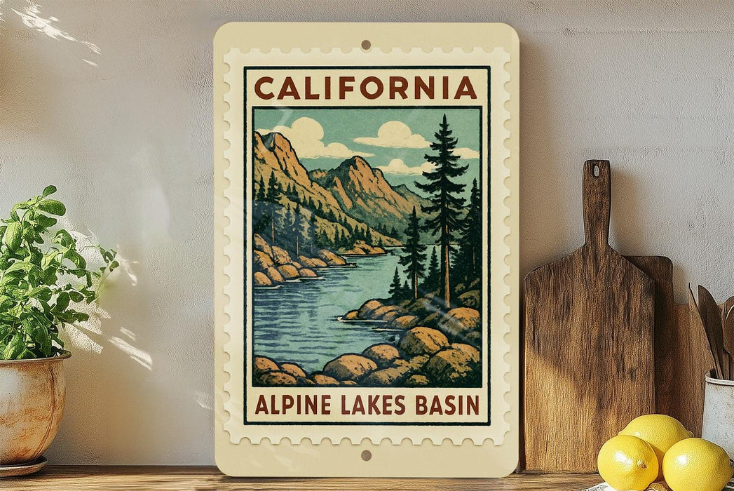A framed vintage-style illustration of the Alpine Lakes basin in California, featuring a mountain landscape with pine trees and a river.