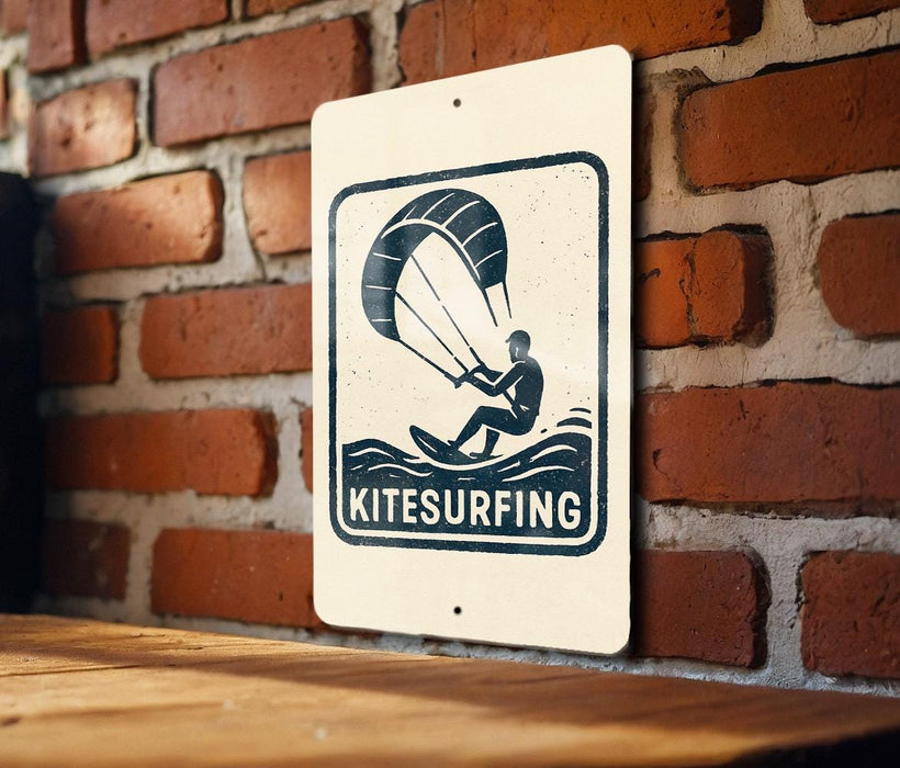 A sign with the word "Kitesurfing" and an illustration of a person kite surfing on a wave, mounted on a brick wall.