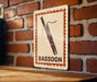 A sign with a picture of a bassoon is mounted on a brick wall.