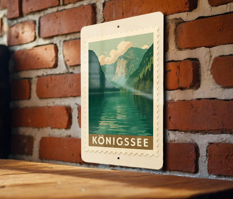 A vintage-style postage stamp featuring a scenic mountain landscape with a lake, hanging on a brick wall.