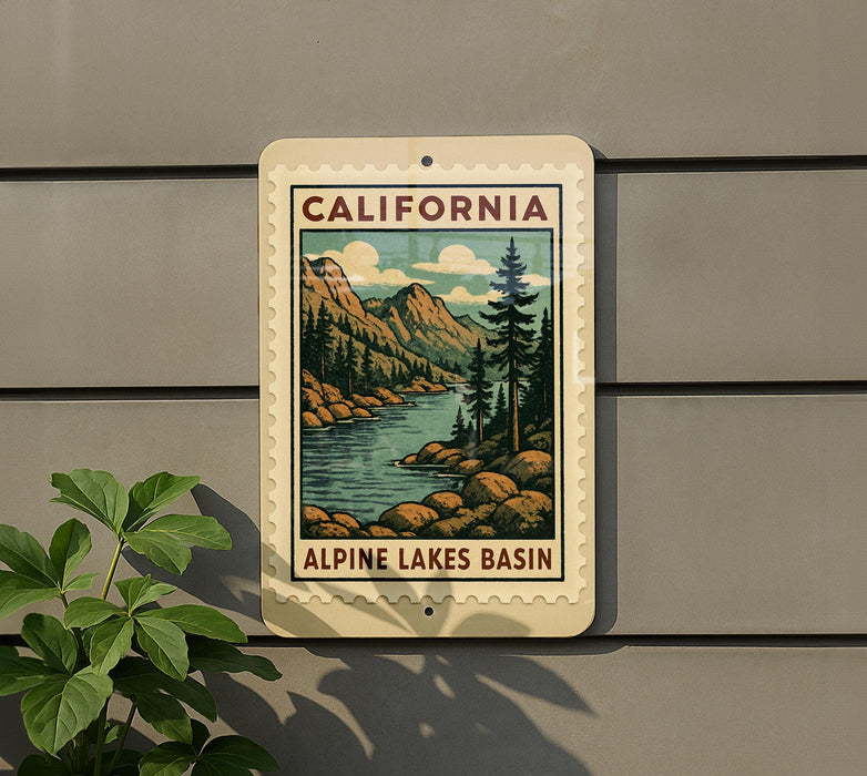 A vintage-style sign for the Alpine Lakes basin in California, featuring a scenic illustration of mountains, trees, and a lake.