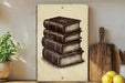 a stack of books on a shelf, with a wooden cutting board and a potted plant nearby.