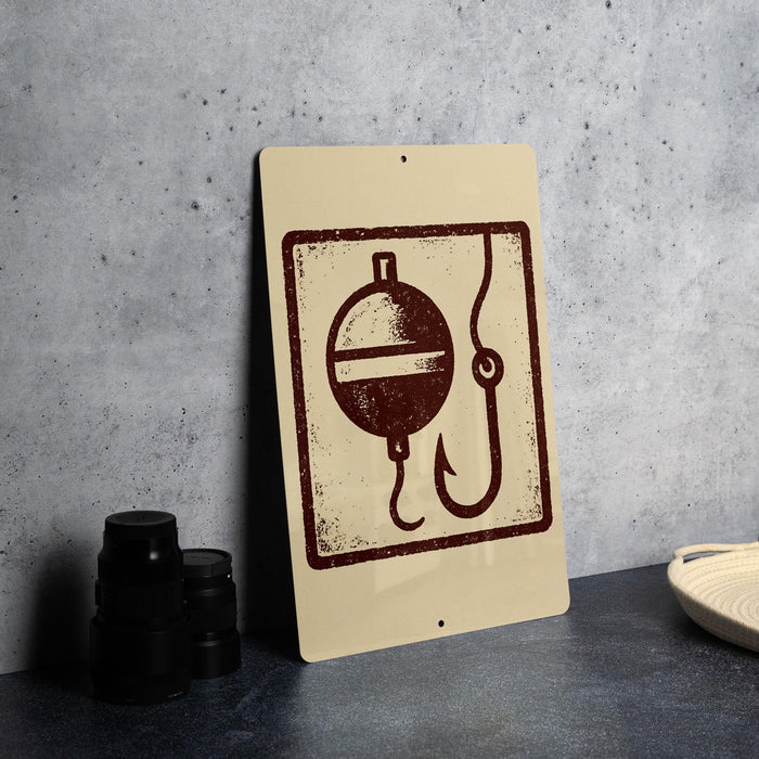 a sign with a fishing symbol, including a bobber and a fishing line, placed on a countertop next to some black camera lenses.