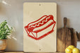 a red hot dog in a box on a shelf, with a potted plant to the left and a wooden cutting board to the right.