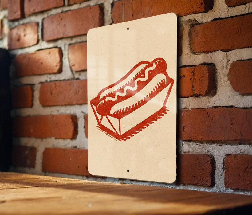 A sign featuring a red hot dog in a cardboard box is mounted on a brick wall.