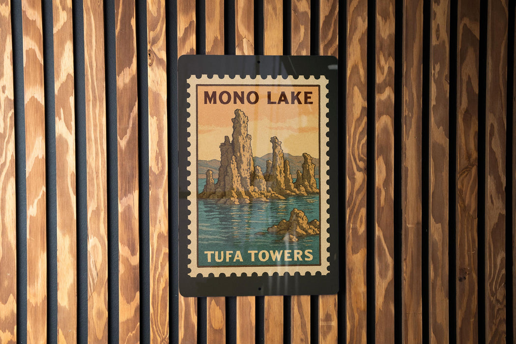 A vintage-style postage stamp depicting the Mono Lake Tufa Towers, with a wooden background.