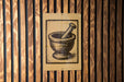 a wooden wall with a sign depicting a mortar and pestle.