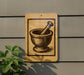 a sign with a picture of a mortar and pestle on it, mounted on a wall.