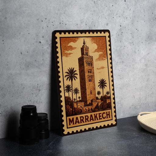 A metal stamp depicting the Marrakech Tower, a famous landmark in Morocco, is displayed on a table.