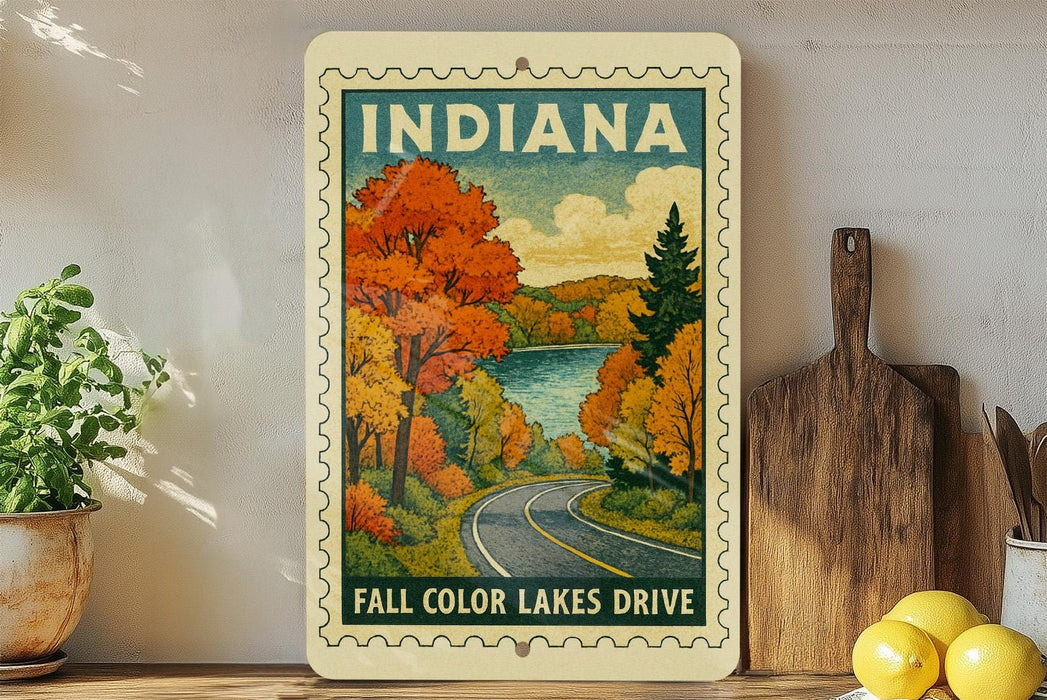 A vintage-style sign depicting a scenic autumn landscape with a road leading through it, surrounded by trees with orange and yellow foliage.