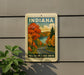 A vintage-style sign for the Fall Color Lakes Drive in Indiana, featuring a scenic autumn landscape with a winding road and colorful trees.