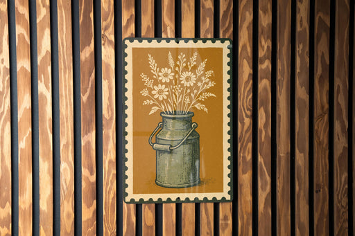 A framed illustration of a vase with flowers is displayed on a wooden wall.
