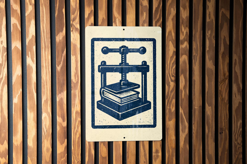 a sign with a blue and white design depicting a book press, mounted on a wooden wall.