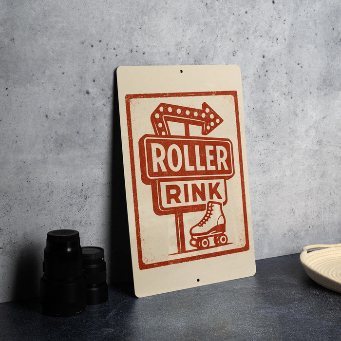 A sign for "Roller Rink" with a roller rink symbol and the word "Rocker" written on it, placed on a countertop next to some black camera lenses.