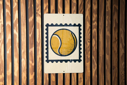 A tennis ball painted on a white sign with a black border, mounted on a wooden wall.