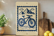 a wooden sign with a bicycle illustration, placed on a wooden surface next to a potted plant and a wooden cutting board.