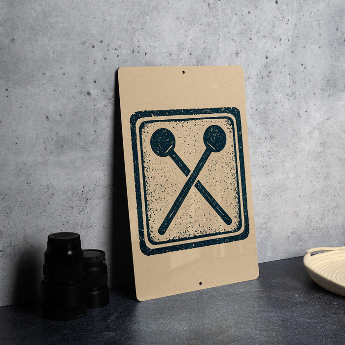 a sign with a graphic design of two crossed drumsticks on a beige background.