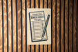 A sign on a wooden wall that reads "THANK YOU DINER CHECK 750189" with a pencil icon.
