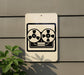 a sign with a tape recorder symbol on it, mounted on a wall next to a plant.