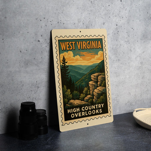 A vintage-style metal sign with the text "WEST VIRGINIA" and "HIGH COUNTRY OVERLOOKS" is displayed on a gray wall, along with a stack of black camera lenses and a white dish.