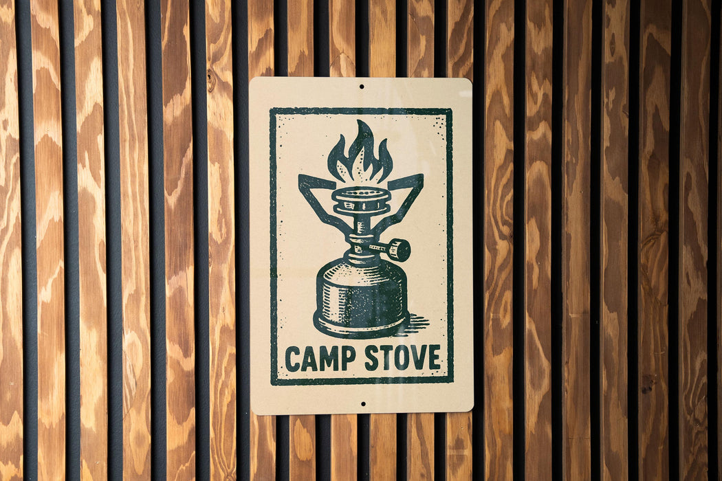 A sign with a graphic of a camp stove is mounted on a wooden wall.