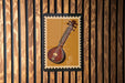 a close-up of a musical instrument, possibly a stringed instrument, displayed on a wooden wall.
