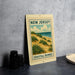 A metal sign with a beach scene and the text "NEW JERSEY COASTAL DUNES" is displayed on a table.